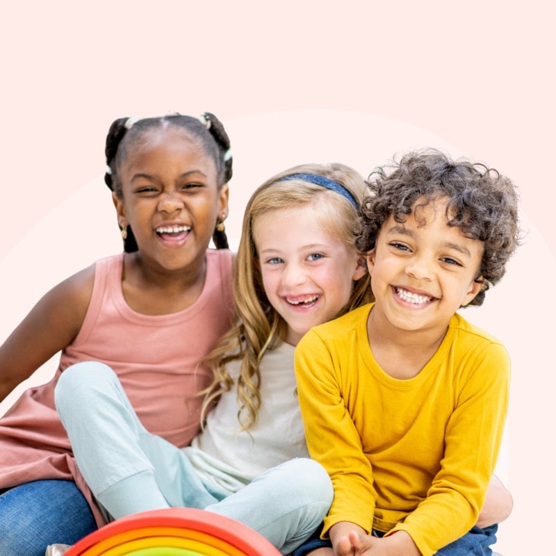 Three young children smiling together