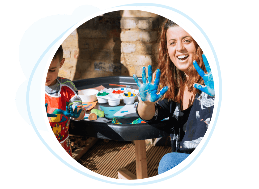 Childminder and child painting together